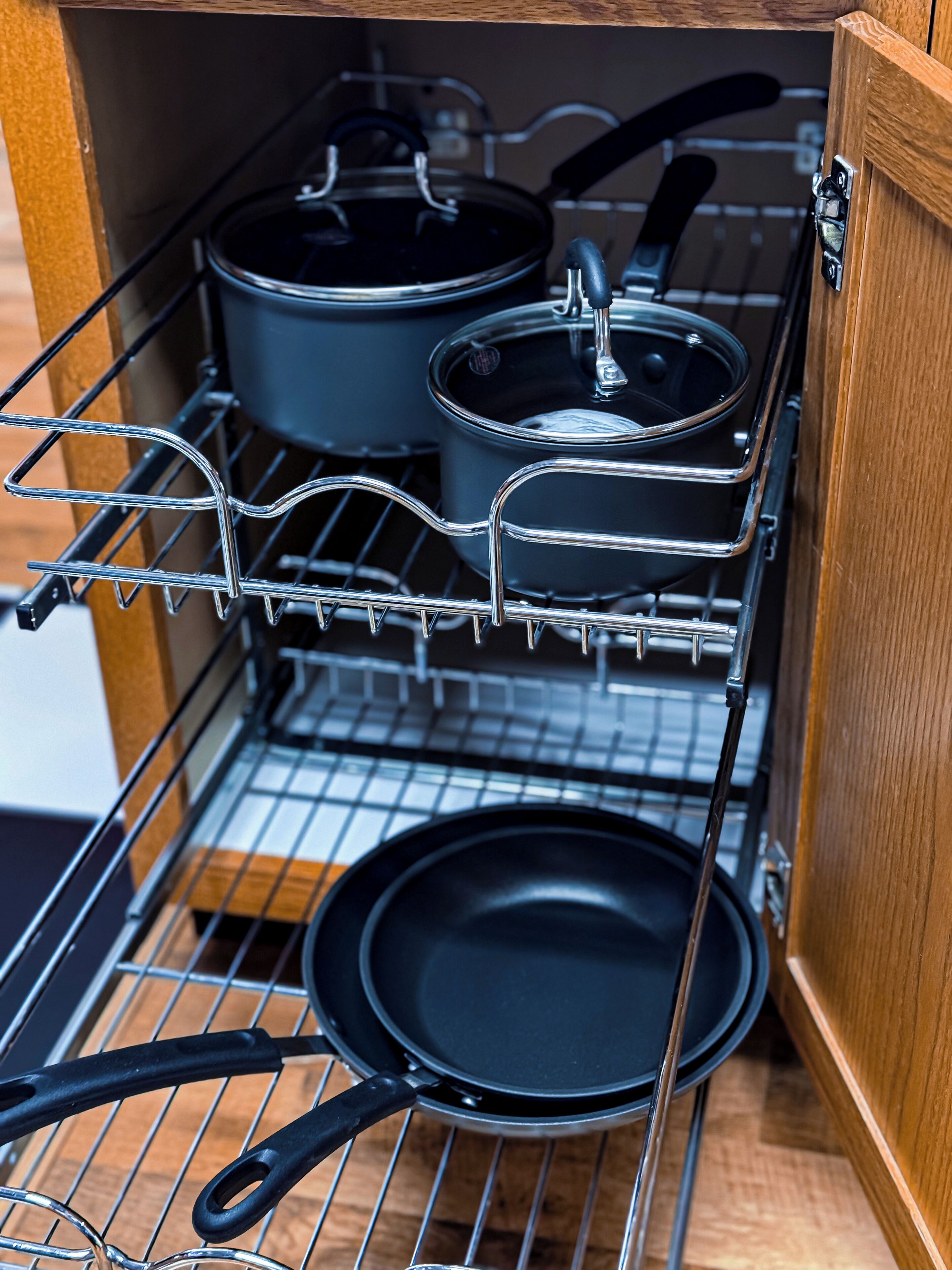 Une cuisine avec un étagère où sont rangées les casseroles et les poêles.