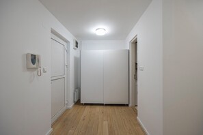 A narrow hallway with wooden flooring, white walls, and a white door at the end. - Belgrade Center Apartment Skadarlija III (Belgrade)