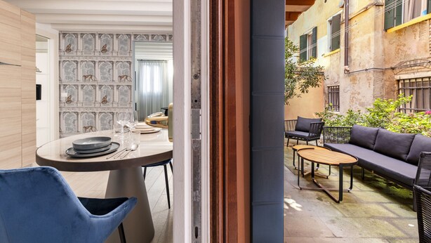 An open-plan living area with a dining table, chairs, and a sofa. - The Blue Light by Wonderful Italy (Venecia)