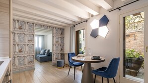 A modern dining area with a round table, blue chairs, and a hexagonal light fixture. - The Blue Light by Wonderful Italy (Venecia)