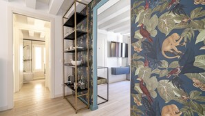 A modern interior with a wooden floor, a metal shelving unit, and a wall with a tropical animal print. - The Green Jungle by Wonderful Italy (Venecia)