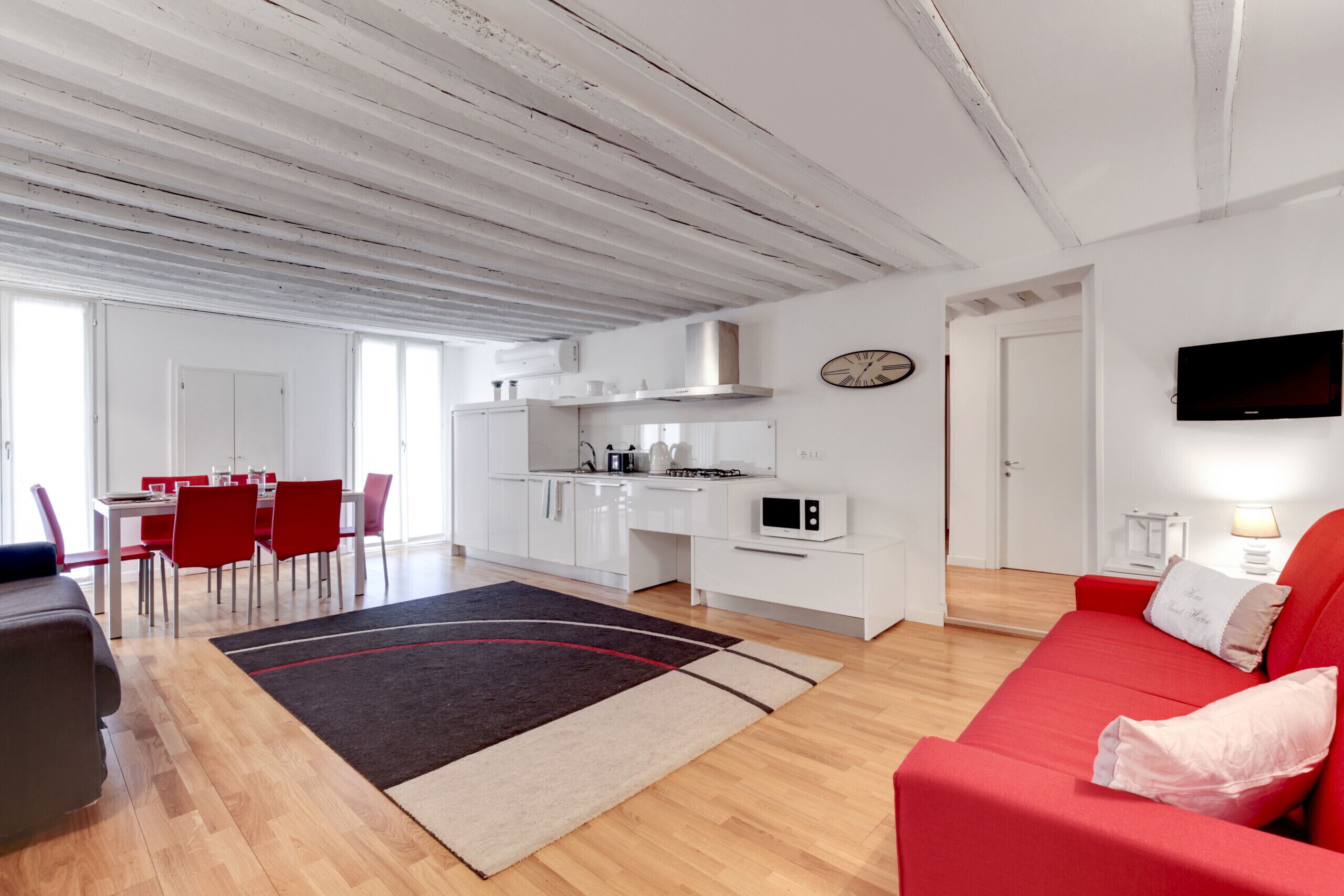 A modern apartment with a dining area, kitchen, and living room.