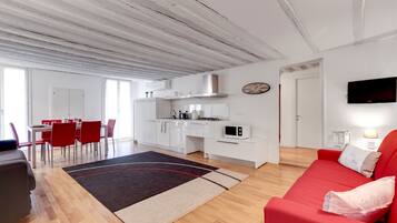 A modern apartment with a dining area, kitchen, and living room.