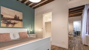 Une chambre à coucher avec un lit, un tableau accroché au mur et un plancher en bois.