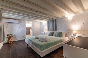 Una camera da letto con un letto, comodini, una lampada, un climatizzatore e una piccola statua.