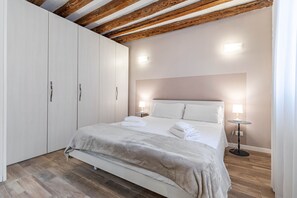 Une chambre à coucher avec un lit, des lampes de chevet, une armoire et un plafond en bois.