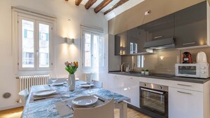 Una cocina moderna con armarios blancos, horno integrado y microondas.