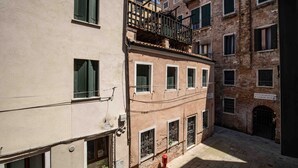 Una calle estrecha con edificios, un hidrante y una señal.