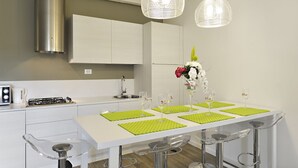 A modern kitchen with a white island, stainless steel appliances, and pendant lighting. - Ca' Forner by Wonderful Italy (Venecia)