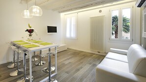 A modern dining area with a white table, clear chairs, and a pendant light fixture. - Ca' Forner by Wonderful Italy (Venecia)