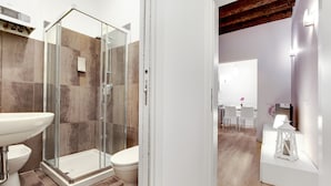 Ein modernes Badezimmer mit einer Duschkabine aus Glas, einem weißen Waschbecken und einer Toilette.