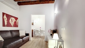 Ein modernes Wohnzimmer mit einem dunkelbraunen Ledersofa, einem weißen Beistelltisch mit einer weißen Laterne und einem roten abstrakten Gemälde an der Wand.