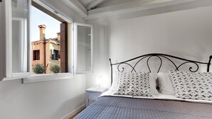 A bedroom with a bed, a window, and a nightstand. - Pozzo Roverso by Wonderful Italy (Venecia)