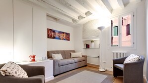 A modern living room with a sofa, armchairs, a coffee table, and a painting on the wall. - Pozzo Roverso by Wonderful Italy (Venecia)