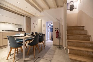 Eine moderne Küche mit Essbereich, einer Treppe und einem Feuerlöscher.