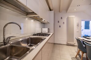 A modern kitchen with stainless steel sinks, a gas stove, and a microwave.