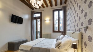 A modern bedroom with a bed, bedside lamp, and a TV mounted on the wall. - Ca' Beccarie 2 by Wonderful Italy (Venecia)
