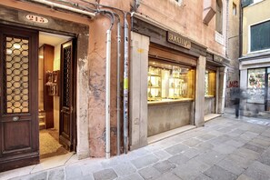 Fachada con un escaparate de vidrio, una puerta con diseño decorativo y un letrero sobre la puerta.
