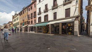 Une rue piétonne bordée de bâtiments historiques, de boutiques et offrant une vue sur un ciel dégagé.