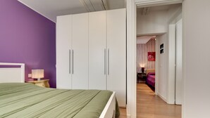 Une chambre à coucher avec un lit, une armoire et une table de chevet.