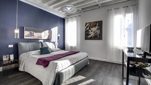 A modern bedroom with a large bed, a desk, and a painting on the wall. - Biennale Apartment by Wonderful Italy (Venecia)