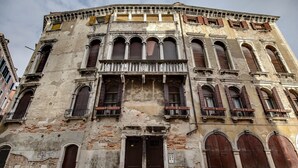 A historic building with multiple arched windows and doors, featuring a weathered facade and traditional architectural details. - Residenza Valier by Wonderful Italy (Venecia)