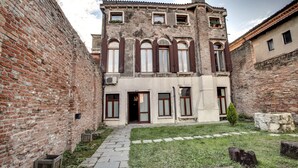Un bâtiment historique doté d’une cour intérieure, de murs en briques et de fenêtres en arc de cercle.