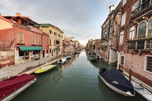 Un canal estrecho bordeado por edificios históricos con barcos amarrados a sus orillas.
