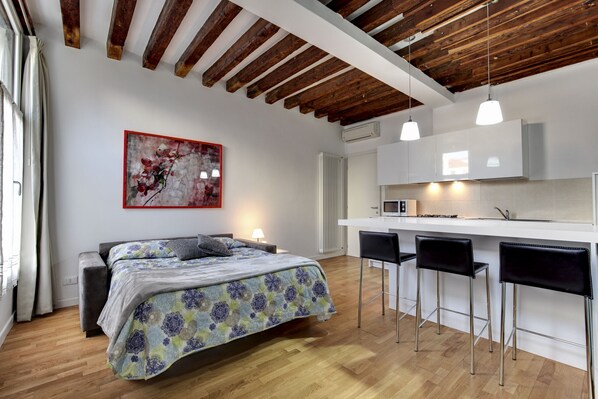 Un dormitorio moderno con cama, mesita de noche y un ventanal amplio.