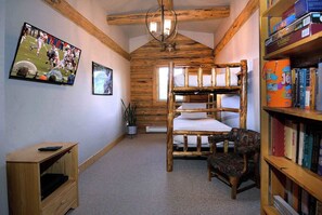 A room with a bunk bed, a bookshelf, a small table, and a television. - "The Lodge" 5BD/5BA, hot tub, pet friendly! (Mt. Crested Butte)