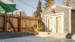 A hot tub with a wooden fence, a shed, and a potted plant. - Spacious Retreat with Hot Tub, Patio, & King Bed (Olympia)