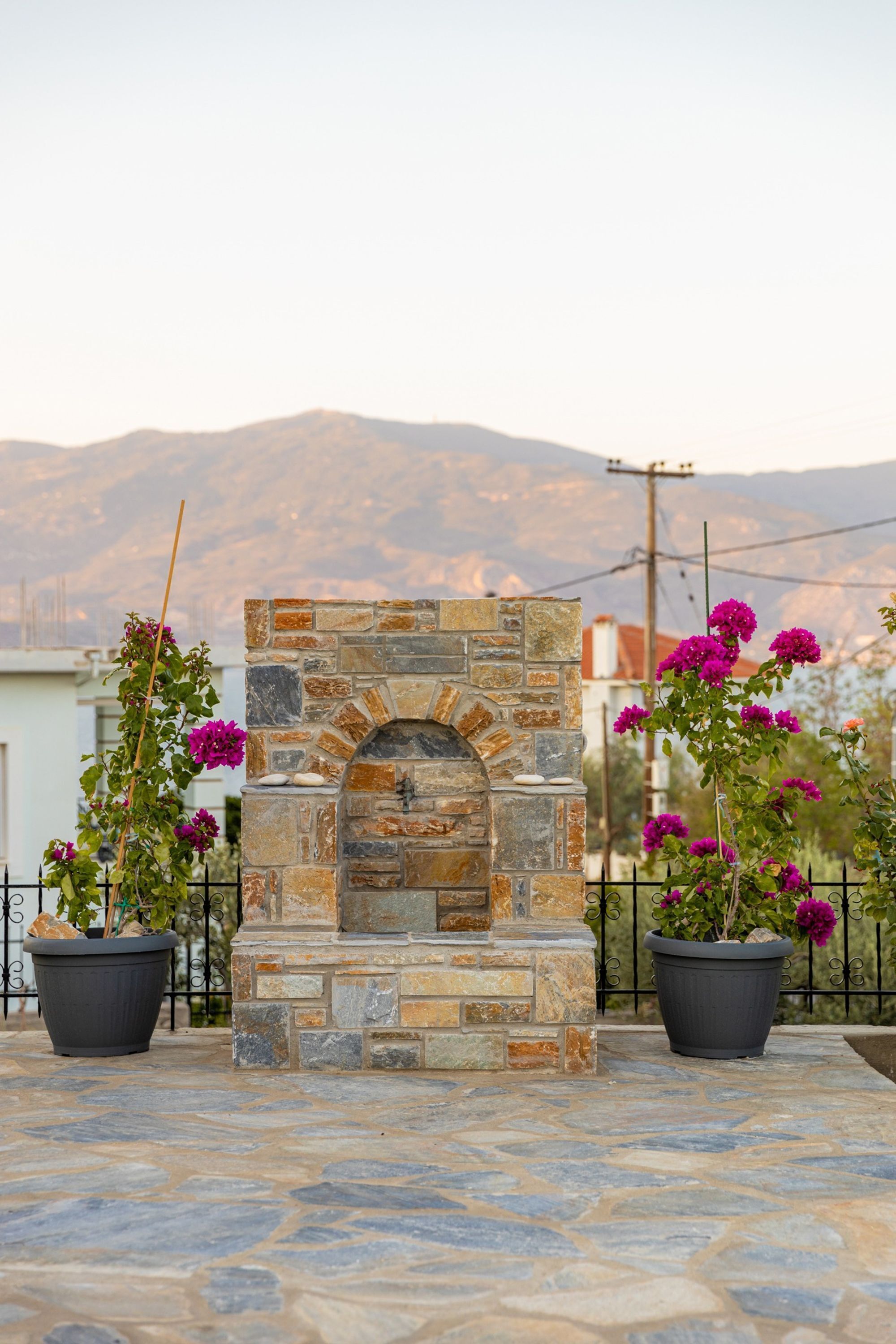 Una chimenea de piedra con vista a montañas al fondo.