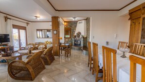 A spacious living area with a fireplace, dining table, and comfortable seating.