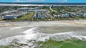Une ville côtière avec des propriétés situées en bord de mer, un pont et un ciel dégagé.