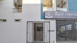 Un hotel llamado "Rush Imperial" con una zona de recepción y una entrada portonada.