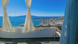 A balcony with a view of a coastal city, a pool, and a rope barrier. - Sunset Shoreline Saranda Hotel (Sarandë)