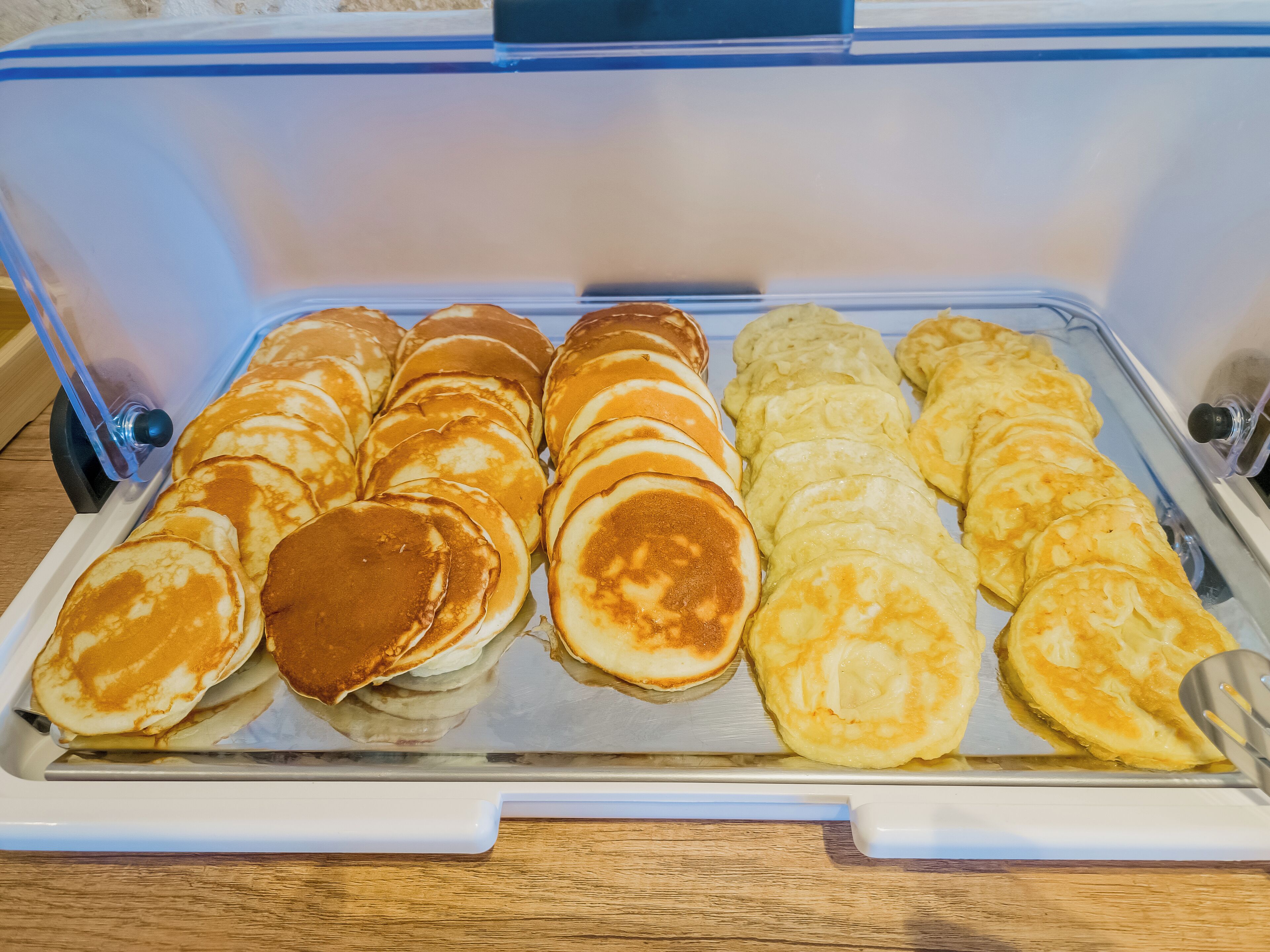 Una bandeja de panqueques con jarabe, dispuesta en una cocina.