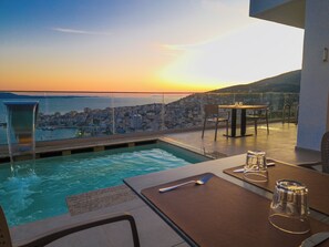 A rooftop pool with a city view at sunset. - Sunset Shoreline Saranda Hotel (Sarandë)