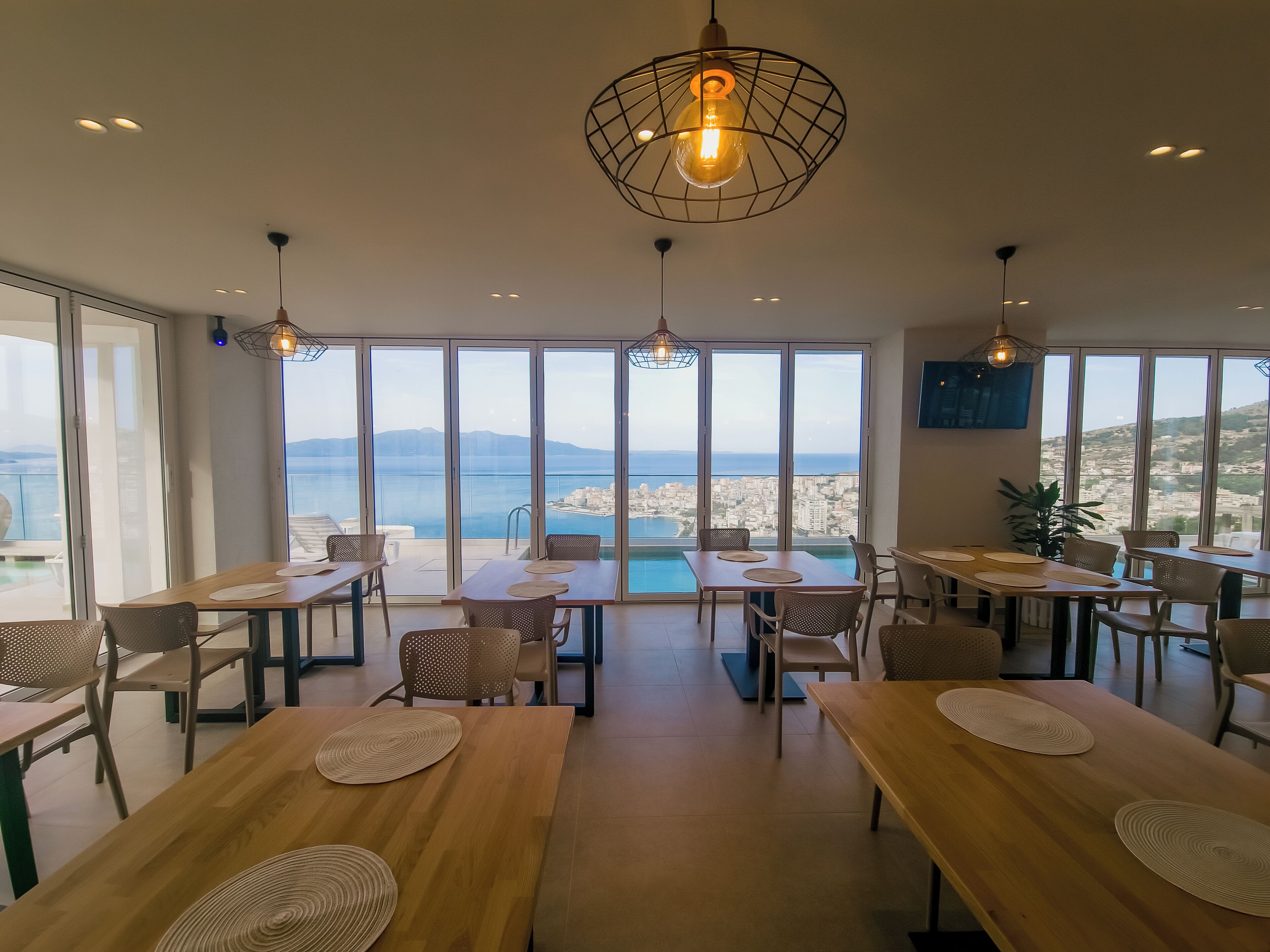 Un comedor amplio con ventanas grandes que ofrecen vistas al mar y a la ciudad.