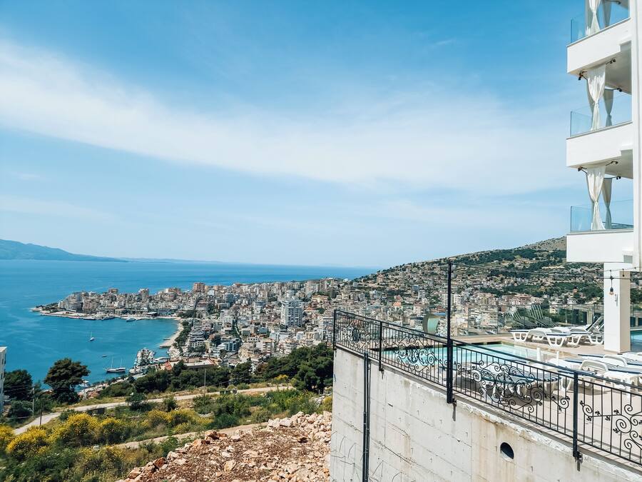 A coastal cityscape with a view of the sea and a modern building with balconies.