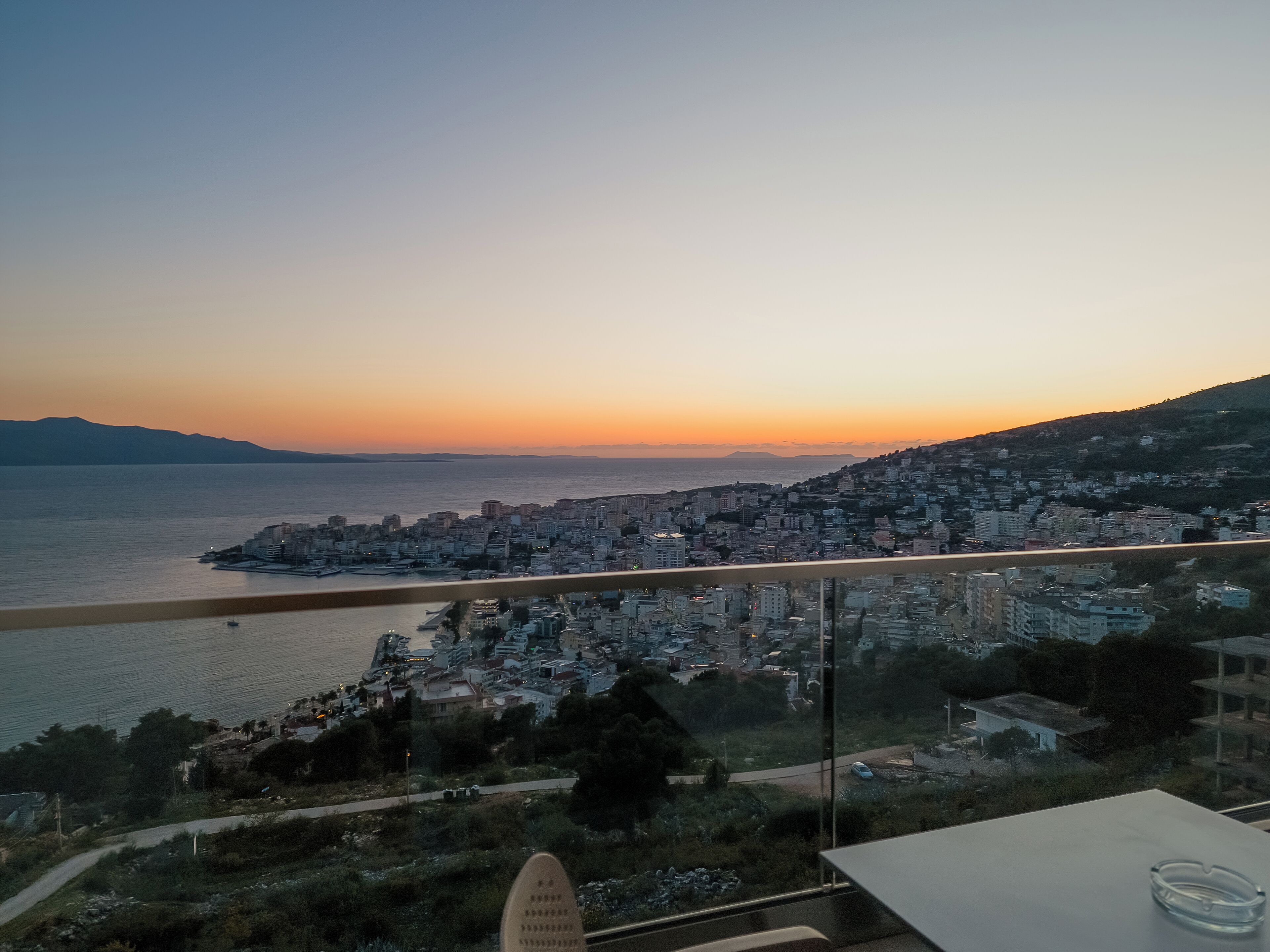 A cityscape with a view of the sea and a bridge.