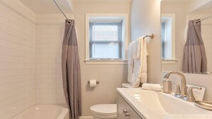 Een badkamer met een bad, toilet en wastafel.