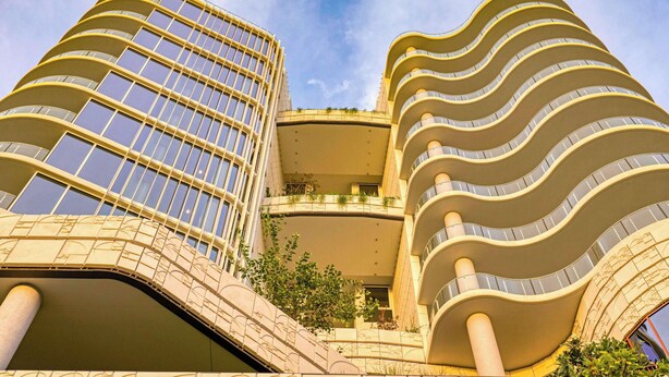 Un bâtiment moderne doté de balcons incurvés et d’une façade en verre.