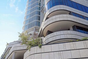 A modern multi-story building with curved balconies and large windows.