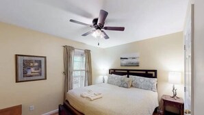 A bedroom with a bed, a ceiling fan, a nightstand, a lamp, and a framed picture on the wall. - Scenic Solitude at Cabins in the Clouds! (Rising Fawn)