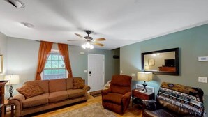 A living room with a sofa, armchair, and a coffee table. - Scenic Solitude at Cabins in the Clouds! (Rising Fawn)