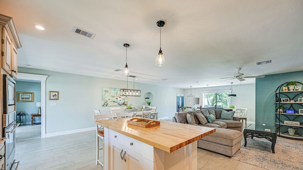 A spacious kitchen with a central island, wooden cabinets, and pendant lighting. - Marco Island Family Home: Pool, Lanai, Backyard! (Marco Island)