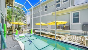 An indoor swimming pool with clear blue water, yellow umbrellas, and a glass ceiling. - Marco Island Family Home: Pool, Lanai, Backyard! (Marco Island)