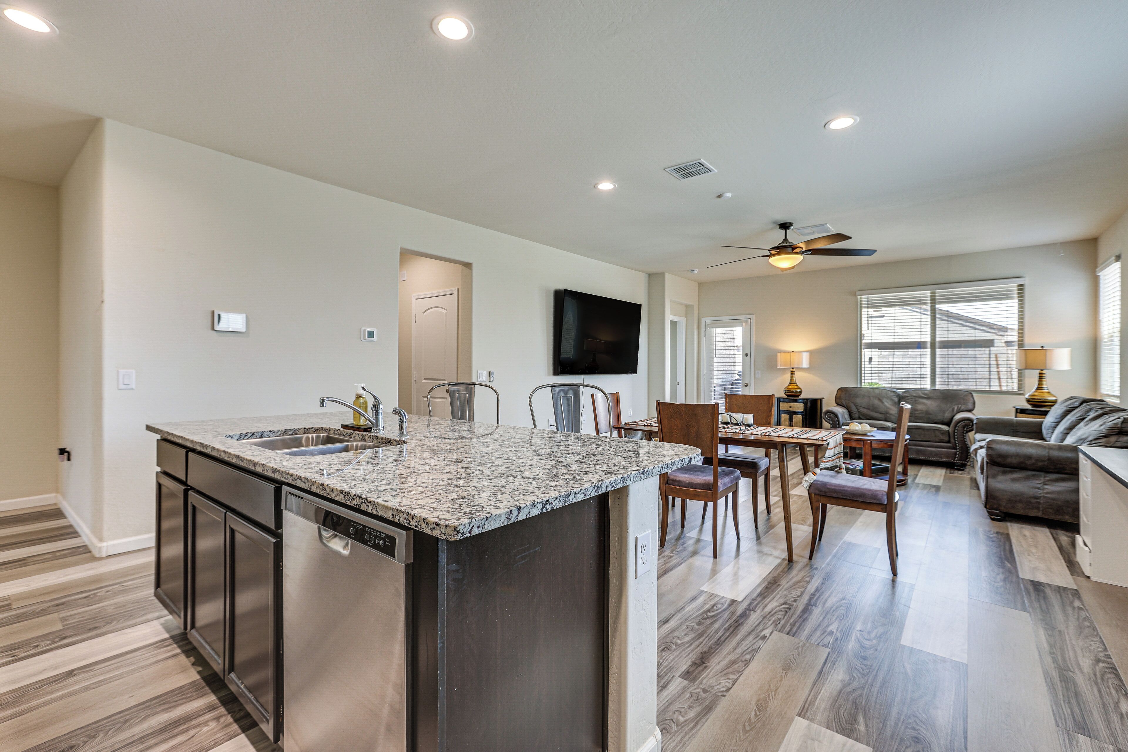 A modern kitchen with a central island, stainless steel appliances, and a dining area with a table and chairs.
