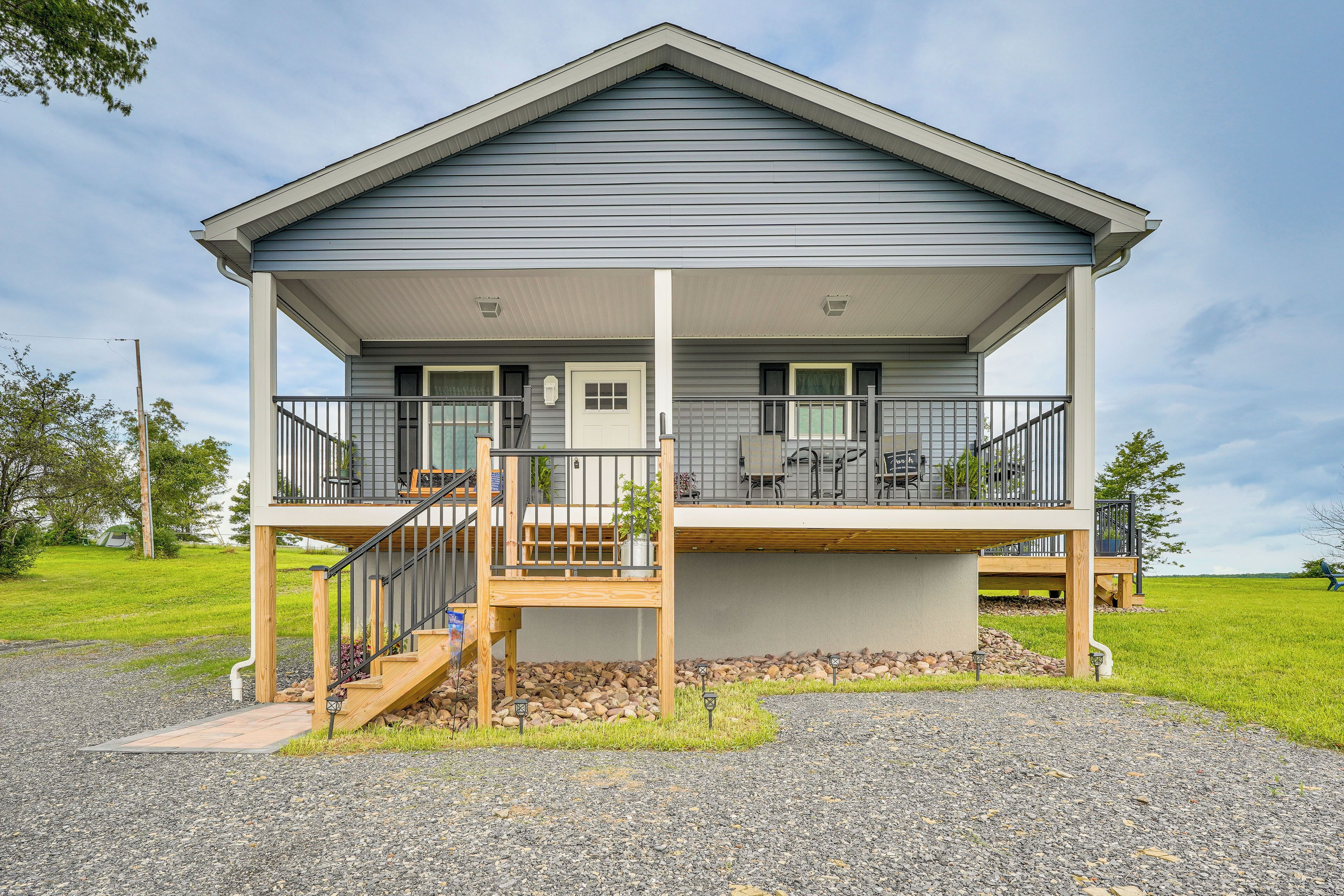 A two-story house with a covered porch and a small deck.